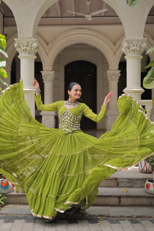 Woman in a green traditional outfit with a flowing skirt in an outdoor setting.