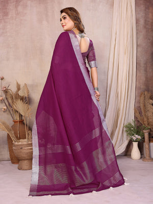 Woman wearing a purple saree with a neutral background