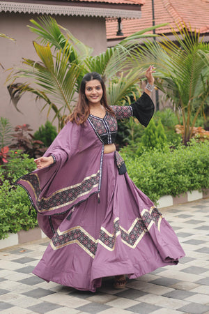 Woman in a traditional outfit dancing outdoors with greenery in the background