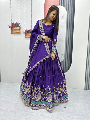 Woman wearing a purple traditional outfit with floral patterns in a minimalistic setting.