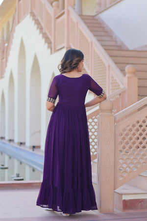 Woman in a purple dress standing on a staircase with a blurred background