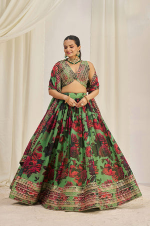 Woman wearing a green and red floral traditional outfit against a white curtain background