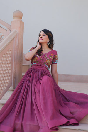 Woman in a pink traditional outfit sitting on steps.