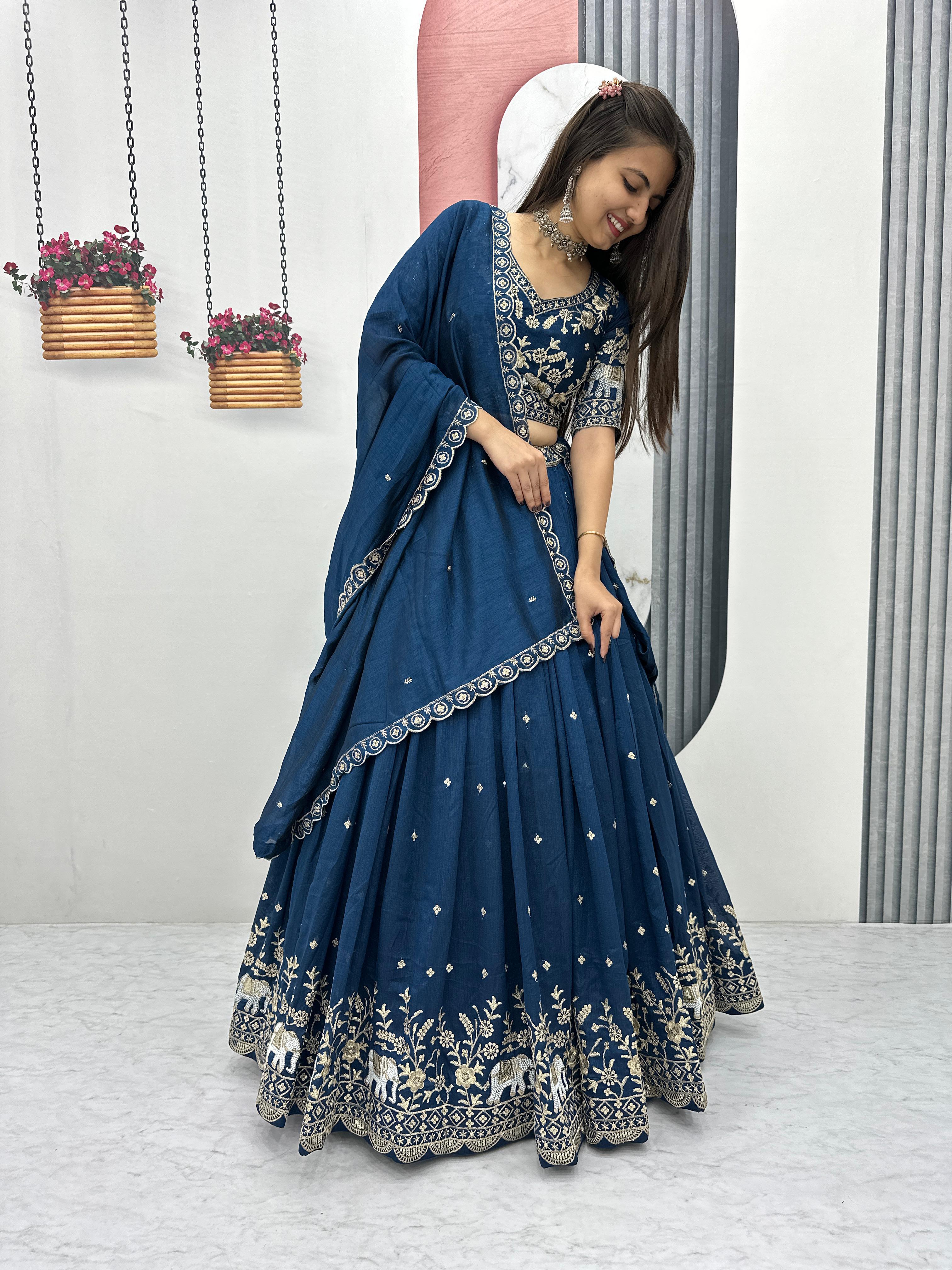 wedding lehenga
Woman in a blue traditional outfit with white patterns standing indoors.