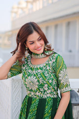Woman wearing a green and white patterned dress sitting outdoors.