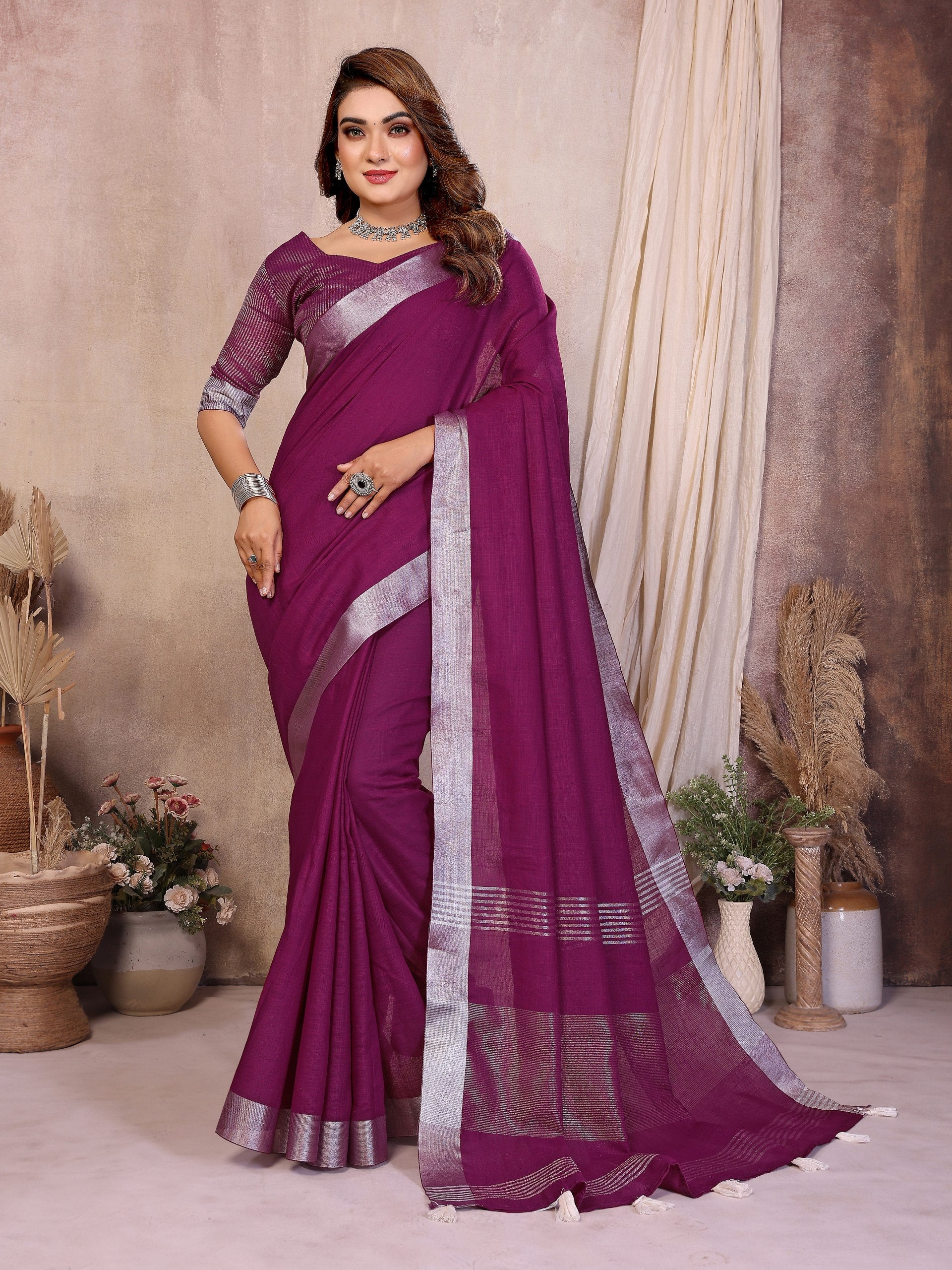 Woman wearing a purple saree with a neutral background