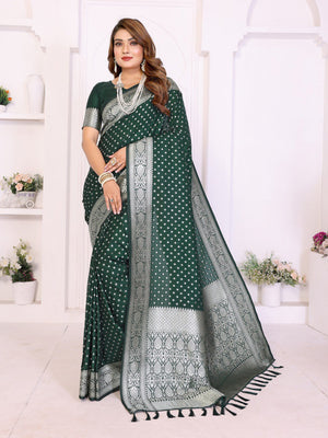 Woman wearing a green saree with white patterns in a white room.