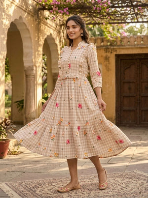 Woman in a floral dress standing in an outdoor setting with architectural elements.