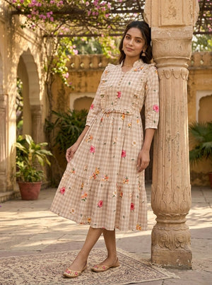 Woman in a floral dress standing next to a decorative column in an outdoor setting.