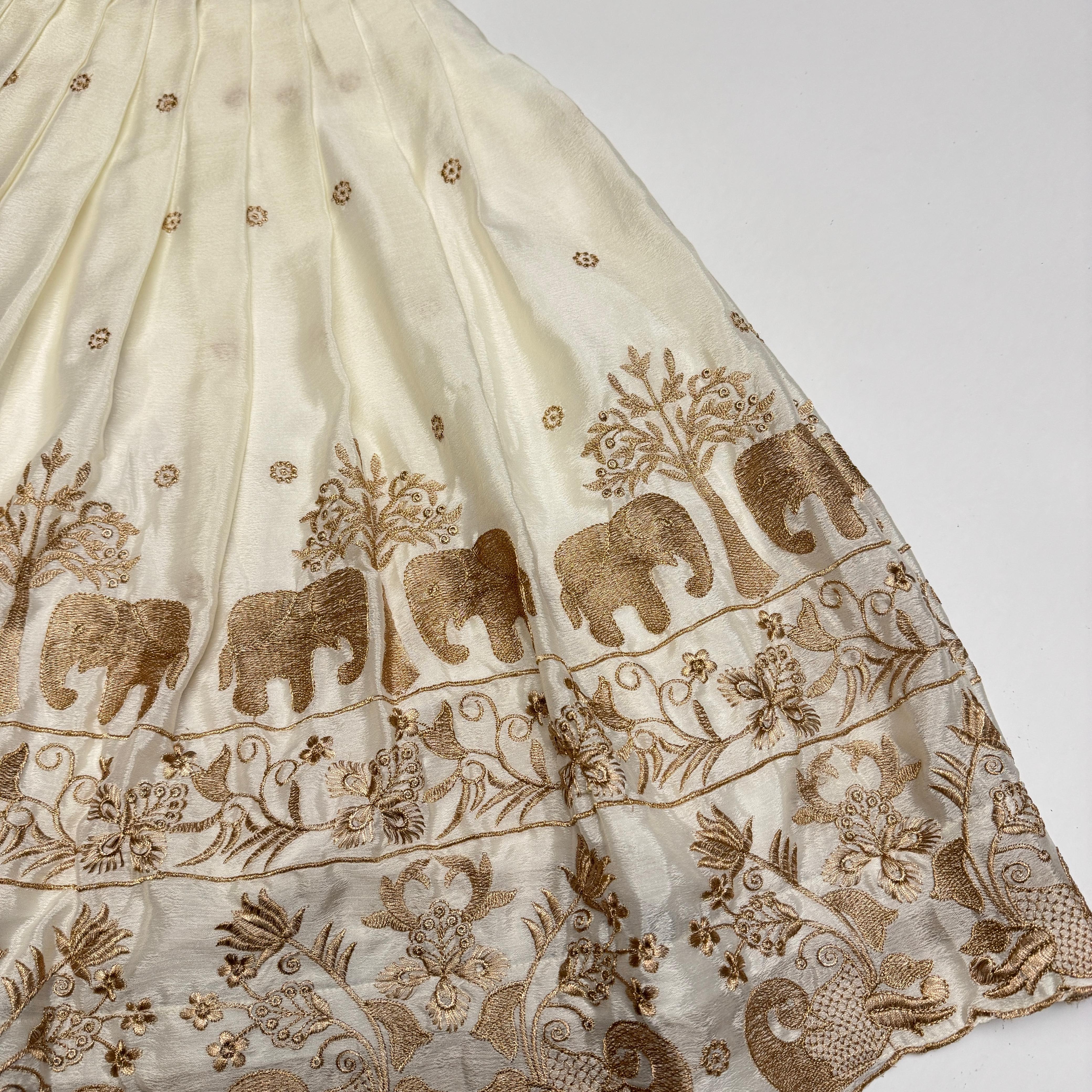 Embroidered fabric with elephants and floral patterns on a white background