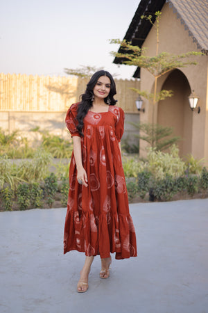 Woman in a red dress standing outdoors with a building and trees in the background