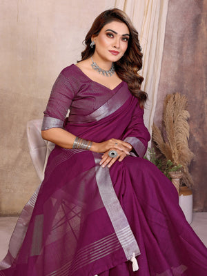 Woman wearing a purple saree with silver border indoors