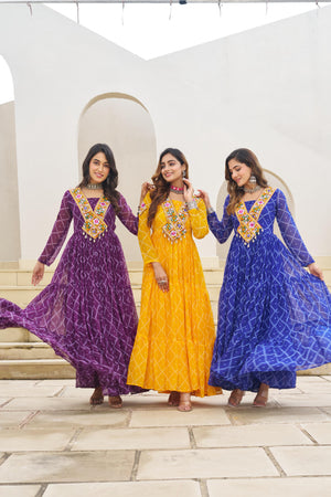 Three women in colorful traditional dresses standing together on a stone path.
