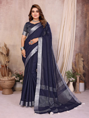 Woman wearing a navy blue saree with silver border in an indoor setting.
