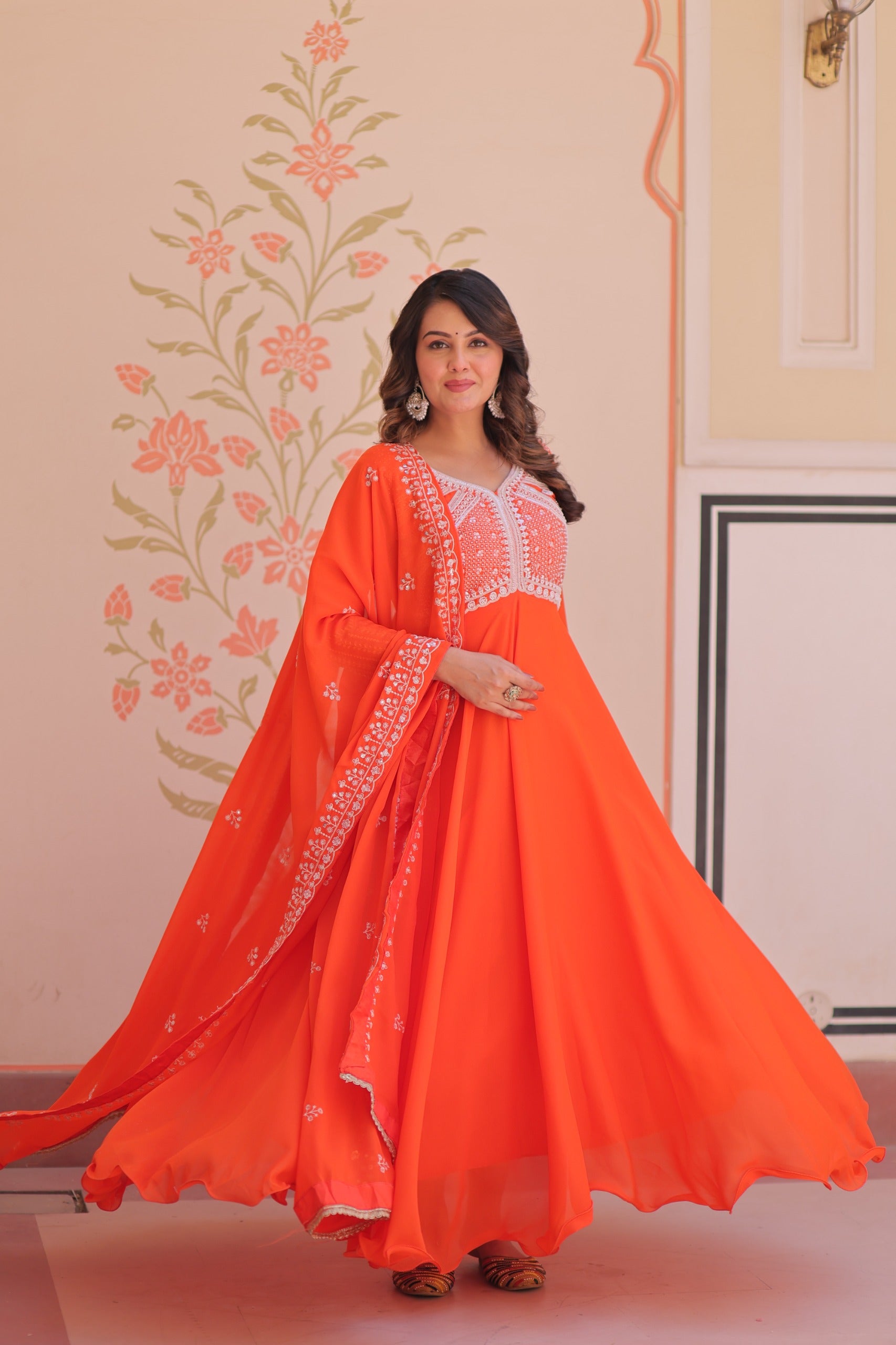 Woman wearing an orange traditional  festive embroidered gown for women.