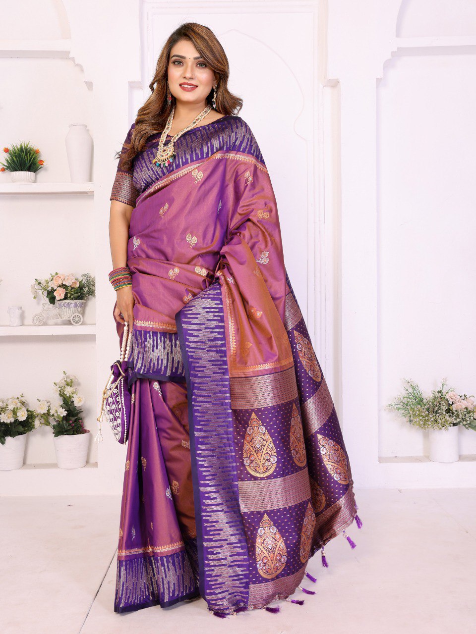 Woman wearing a purple and pink saree with a white background