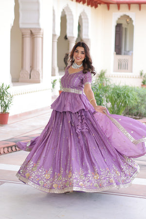 Woman in a purple embroidered dress standing in a garden setting