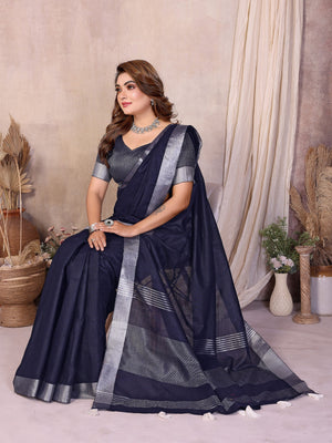 Woman wearing a navy blue saree with silver border in an indoor setting.