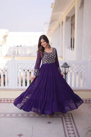 Woman in a purple dress standing on a balcony with white railings and columns.