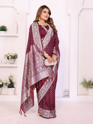 Woman wearing a maroon saree with white patterns in a white room.