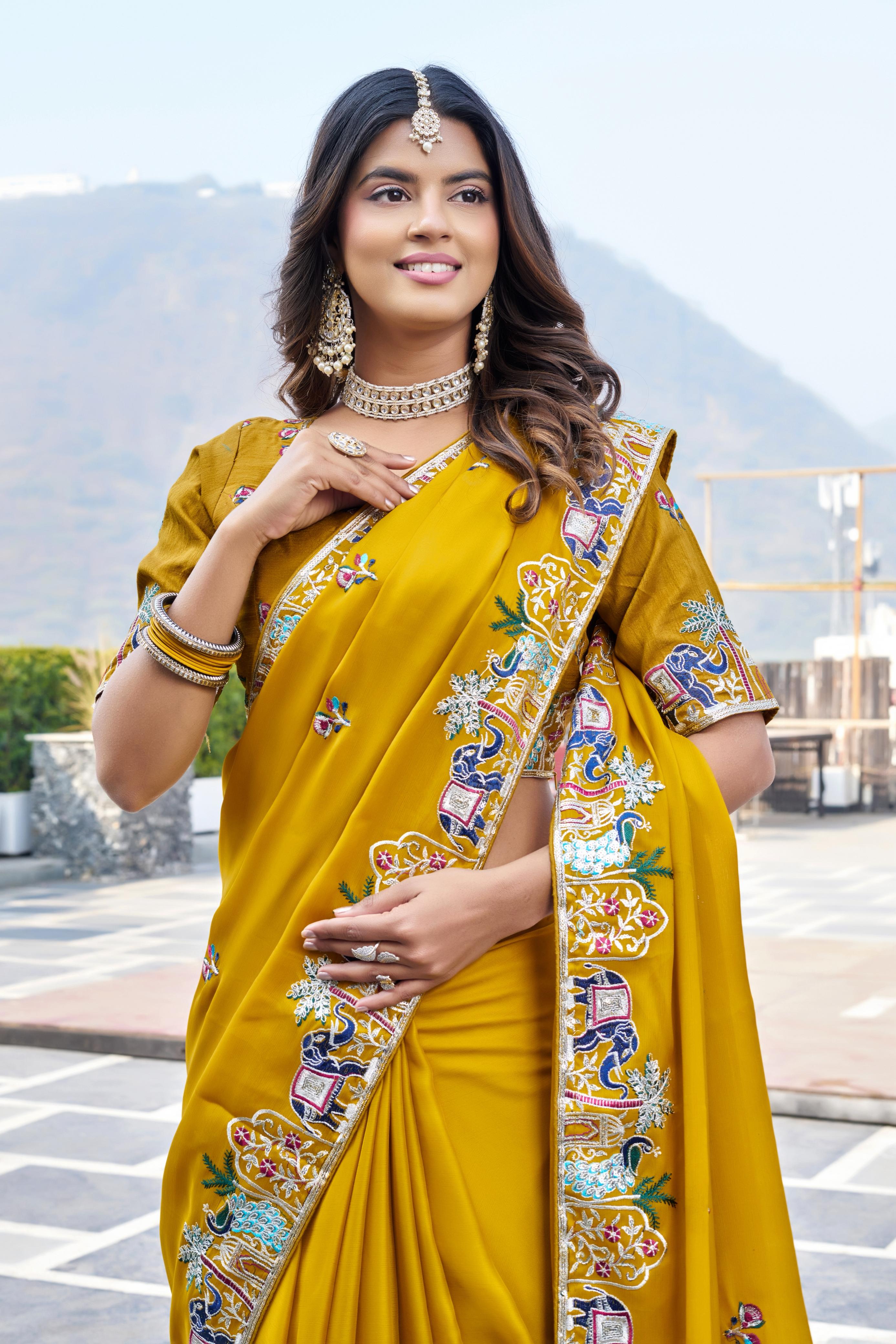 Woman wearing a yellow saree with floral patterns outdoors.