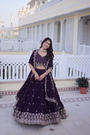 Woman in a dark purple traditional outfit standing on a balcony with white railings.