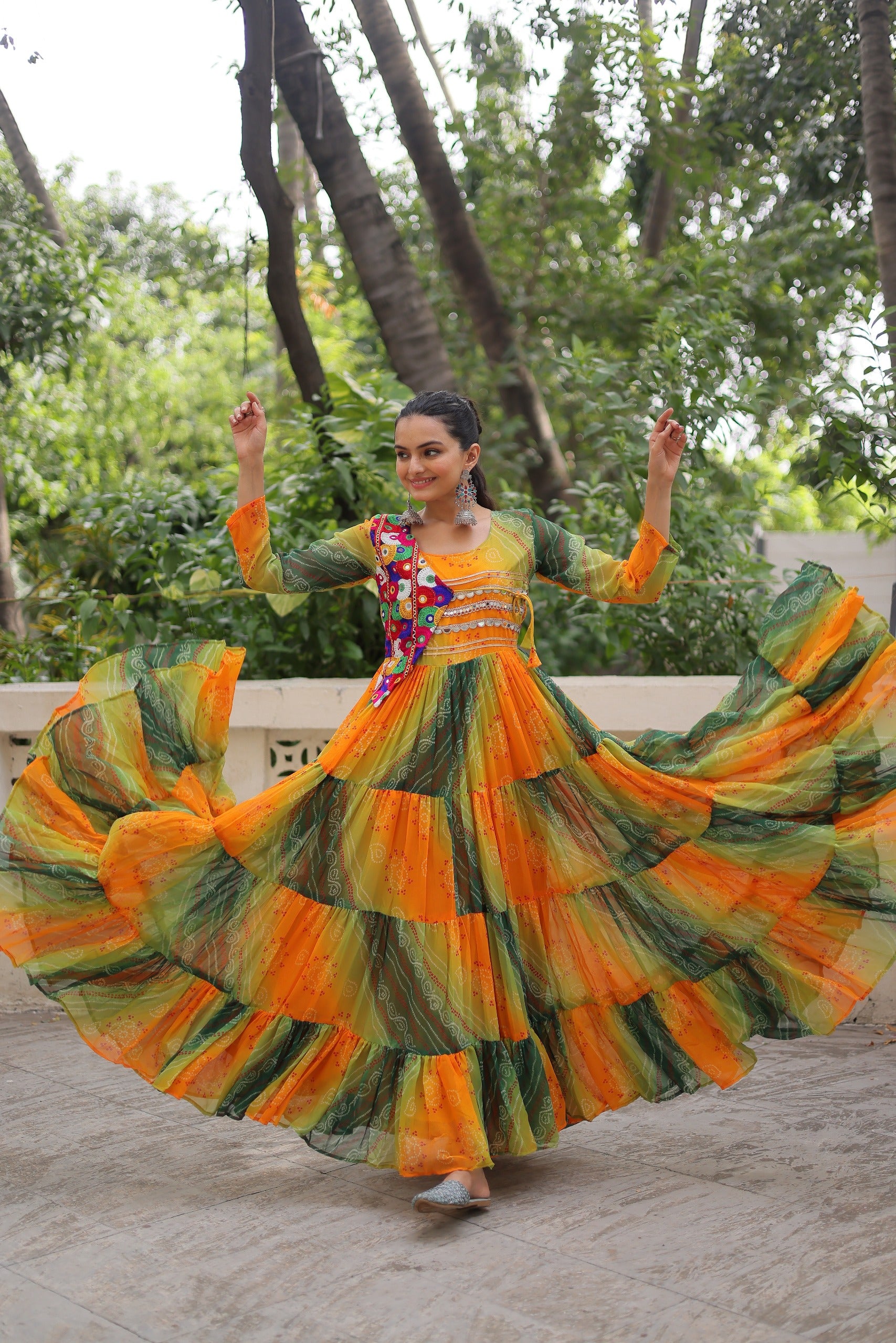 Model twirling in Green-Orange Kutchi Work Gown