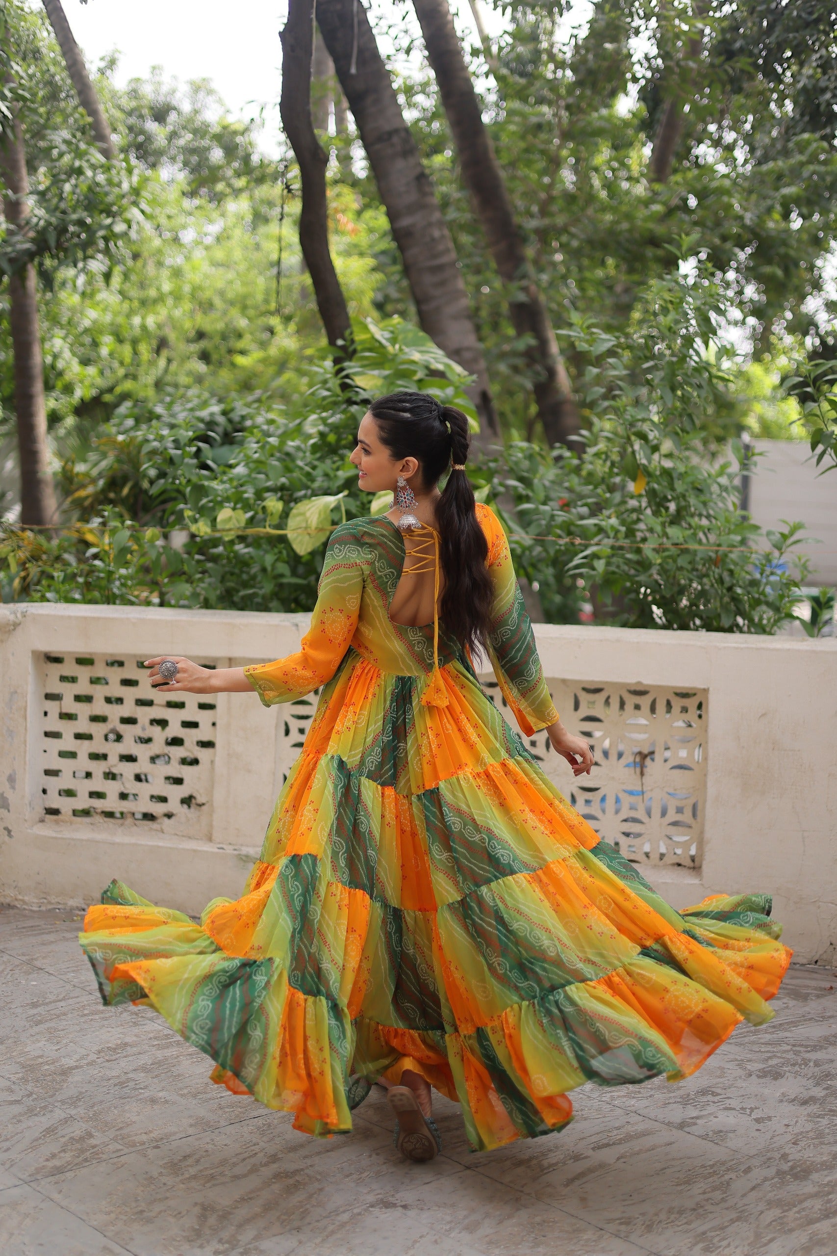 Model twirling in Green-Orange Kutchi Work Gown