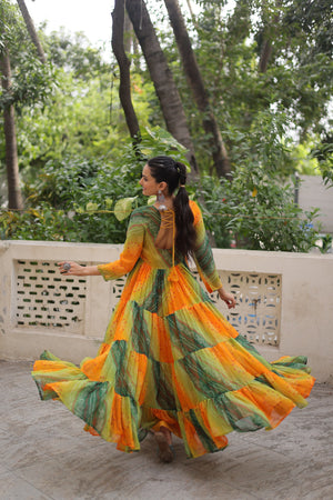 Model twirling in Green-Orange Kutchi Work Gown