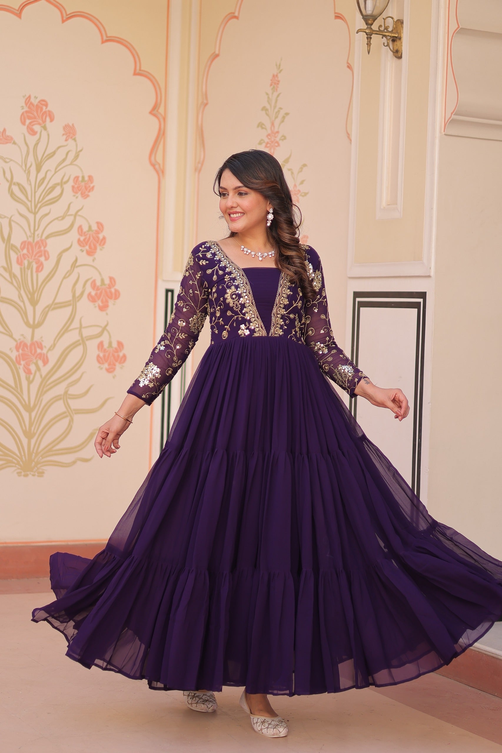 Woman wearing a purple gown with floral patterns in an indoor setting