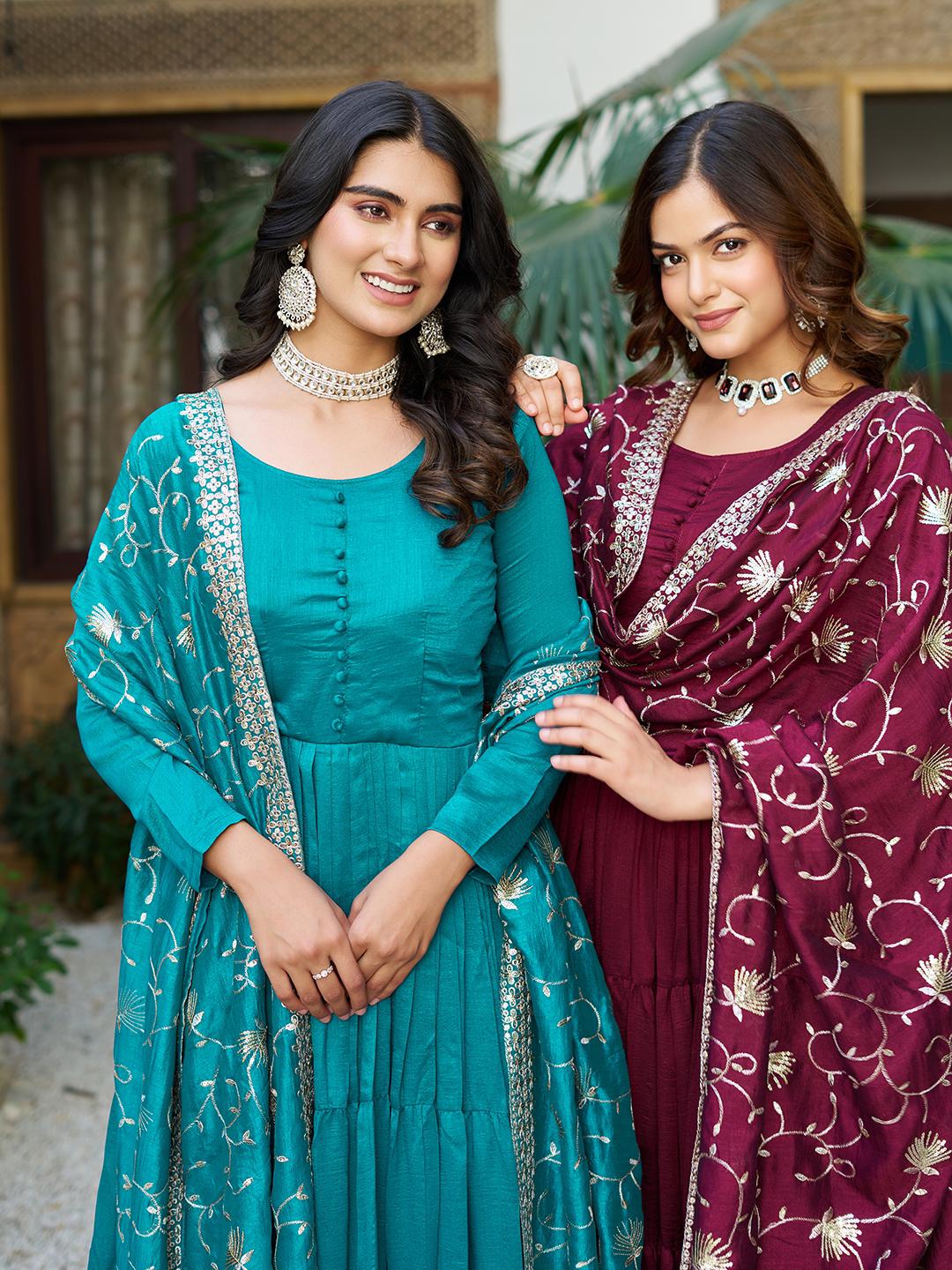 Two women in traditional attire standing together outdoors.
