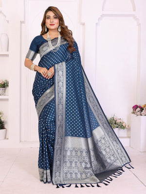 Woman wearing a blue saree with white patterns in a bright indoor setting